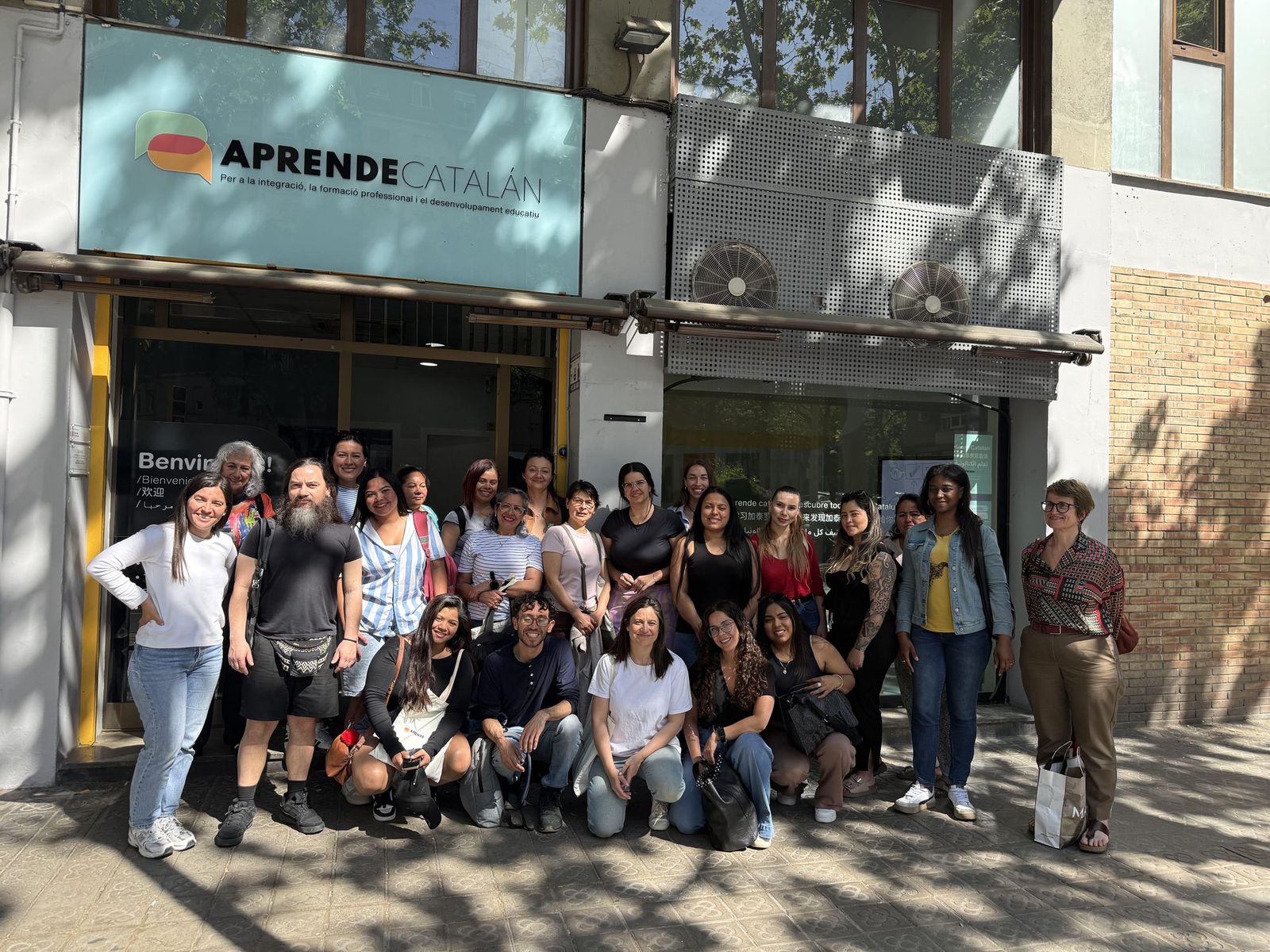 Grupo de alumnos adultos delante de la academia Aprendecatalan
